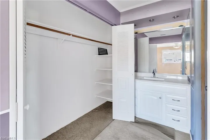 Bathroom featuring vanity and a spacious closet