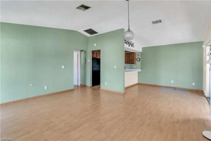 Unfurnished living room with light wood-type flooring and baseboards
