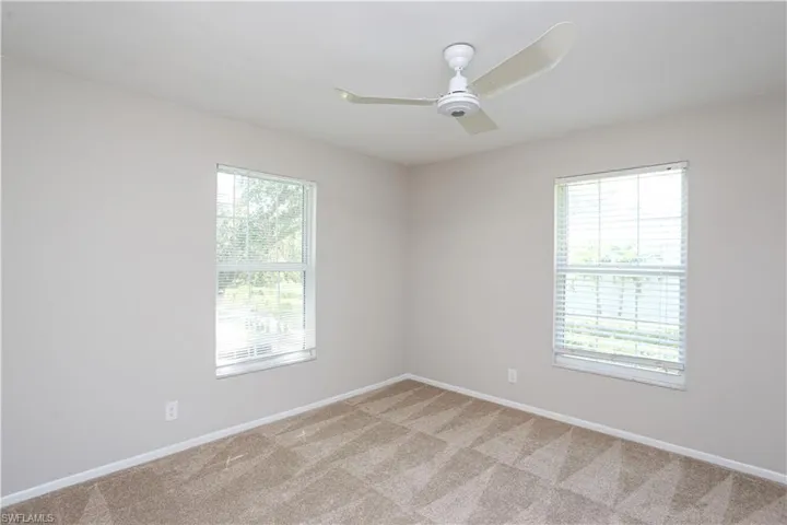 Carpeted spare room with ceiling fan