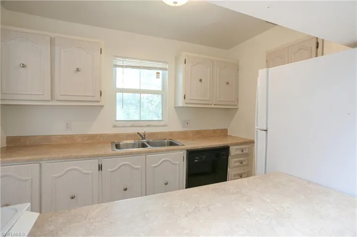 Kitchen featuring sink, white refrigerator, and dishwasher