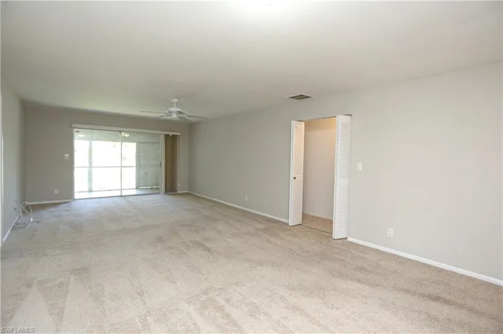Carpeted empty room with ceiling fan