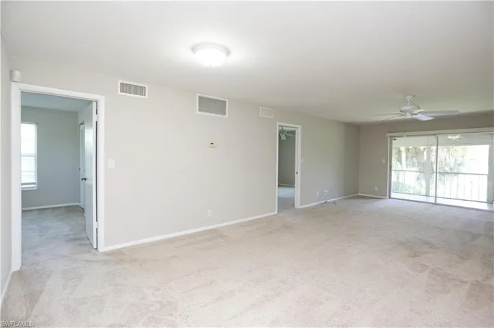 Unfurnished room featuring ceiling fan and light colored carpet