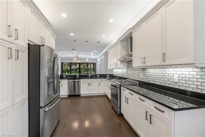Kitchen features stainless steel appliances, hood vent, pantry, and plenty of storage