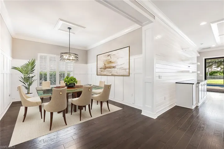 Large formal dining, open to kitchen and great room, boasting elegant wood trimming, designer lighting, and plantation shutters. (virtually staged)