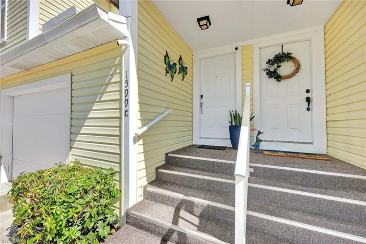 Property entrance with covered porch and a garage