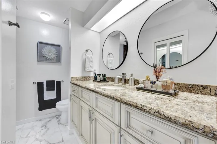 Bathroom with vanity and light marble finish floors