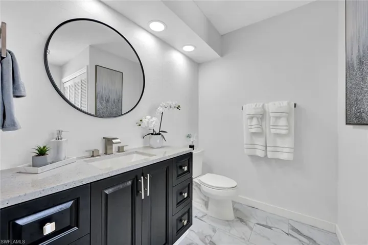 Bathroom featuring vanity and light marble finish flooring
