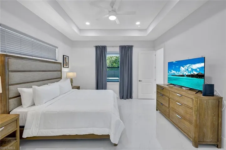 Bedroom featuring ceiling fan, recessed lighting, and a raised ceiling