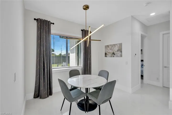Dining area featuring baseboards and a chandelier
