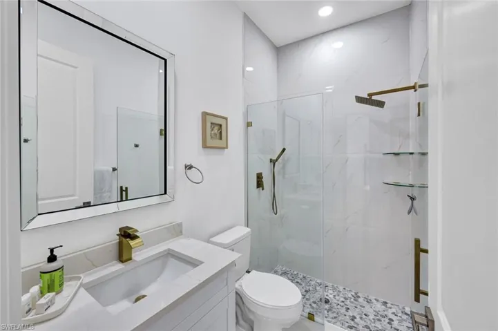Full bath featuring a marble finish shower, vanity, and recessed lighting