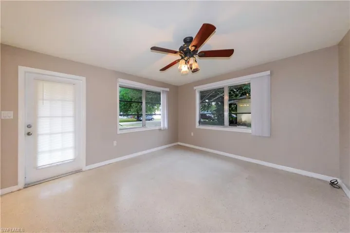 Empty room featuring ceiling fan and a wealth of natural light
