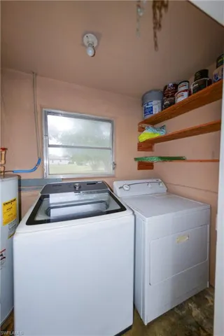 Laundry area featuring water heater and washing machine and clothes dryer
