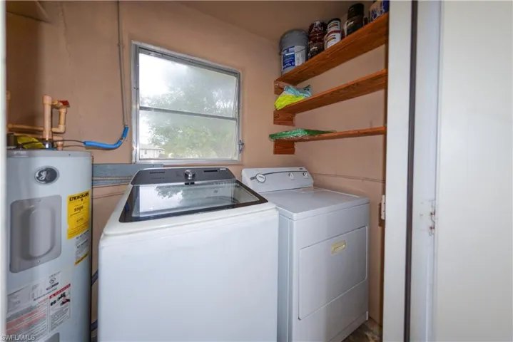 Laundry room featuring washer and clothes dryer and electric water heater