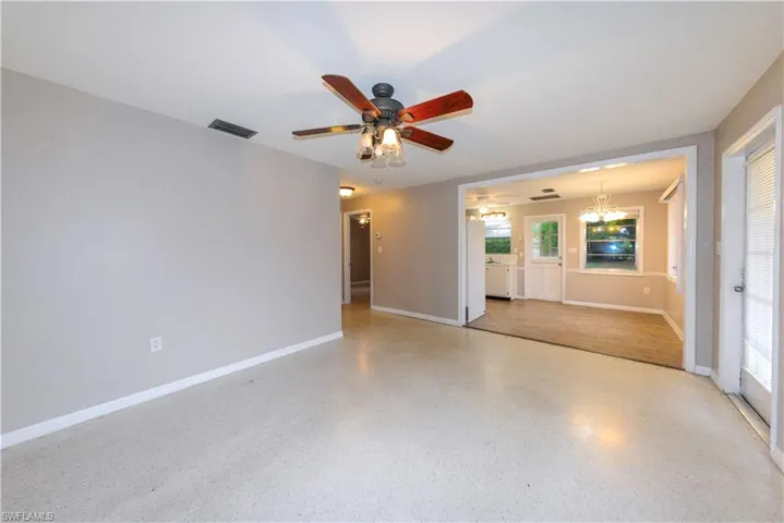 Unfurnished living room with ceiling fan with notable chandelier