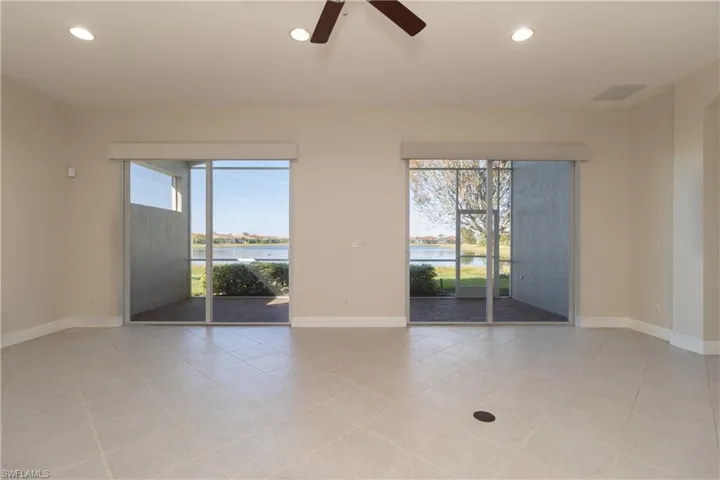 Spare room with a water view, ceiling fan, and light tile patterned floors