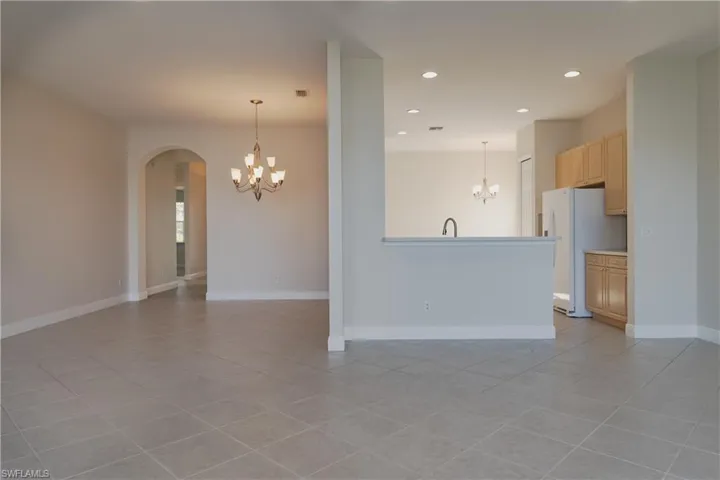 Tiled empty room with an inviting chandelier