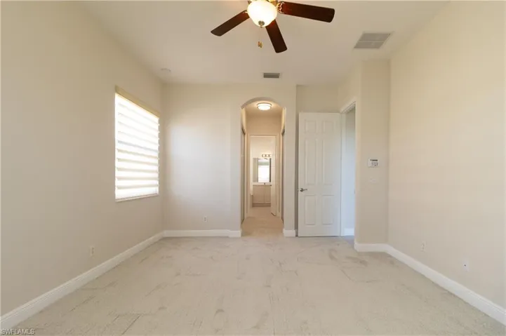 Spare room featuring light colored carpet and ceiling fan