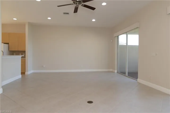 Unfurnished living room with ceiling fan and light tile patterned floors