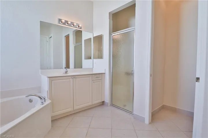 Bathroom featuring vanity, plus walk in shower, and tile patterned floors