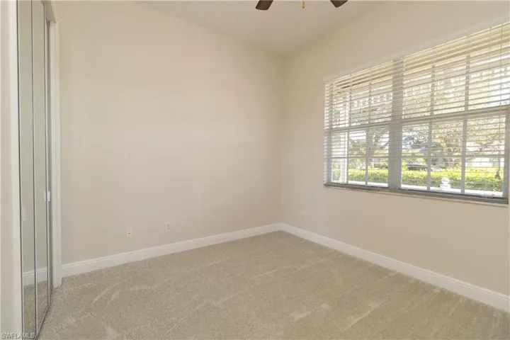 Carpeted empty room featuring ceiling fan