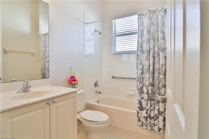 Full bathroom with toilet, vanity, and shower / tub combo