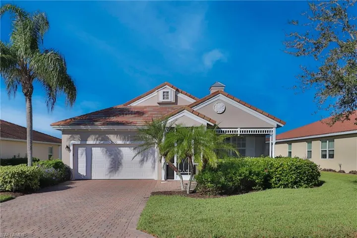 View of front of property with a garage and a front lawn