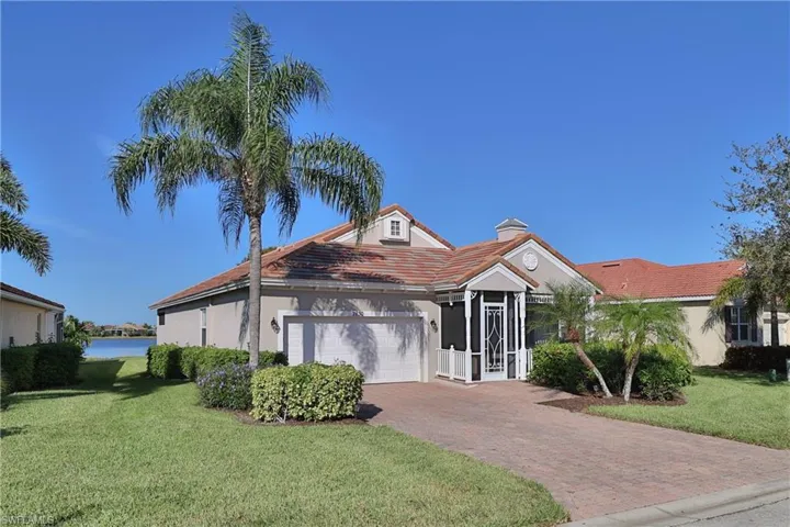 View of front facade with a water view, a front yard, and a garage