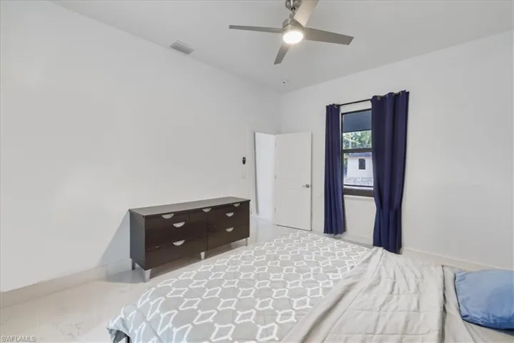Bedroom featuring marble finish floor, visible vents, ceiling fan, and baseboards