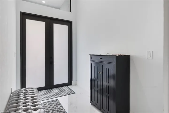 Foyer entrance featuring marble finish floor and baseboards
