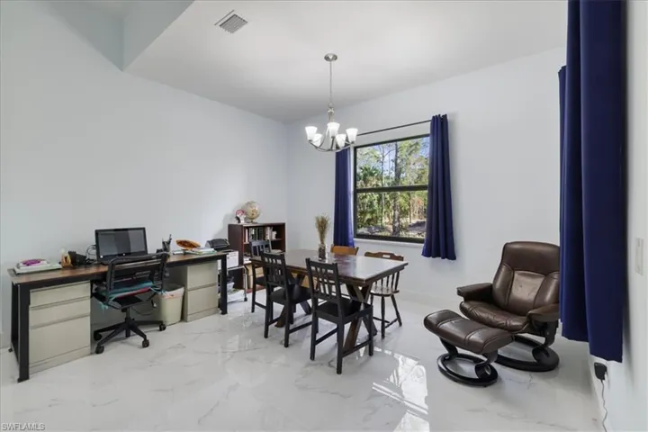 Office space featuring baseboards, visible vents, a notable chandelier, and marble finish floor