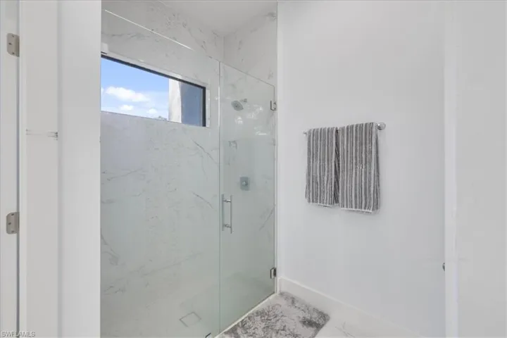 Full bathroom with baseboards, a marble finish shower, and marble finish floor