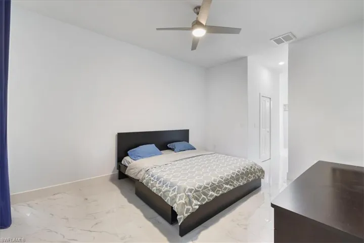 Bedroom featuring baseboards, visible vents, a ceiling fan, and marble finish floor