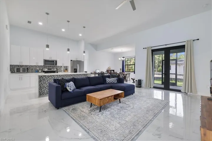 Living area with recessed lighting, a toaster, marble finish floor, ceiling fan with notable chandelier, and visible vents