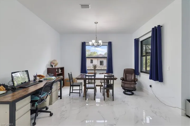Dining area featuring a chandelier, visible vents, and marble finish floor