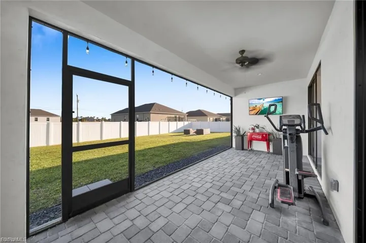 Unfurnished sunroom with a patio area and ceiling fan