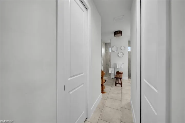 Hallway with light tile patterned floors and baseboards