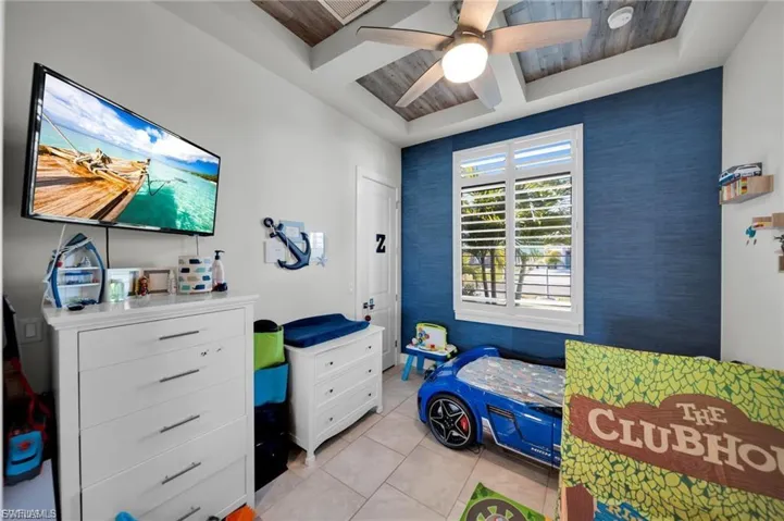 Bedroom featuring coffered ceiling, a ceiling fan, light tile patterned floors, and wood ceiling