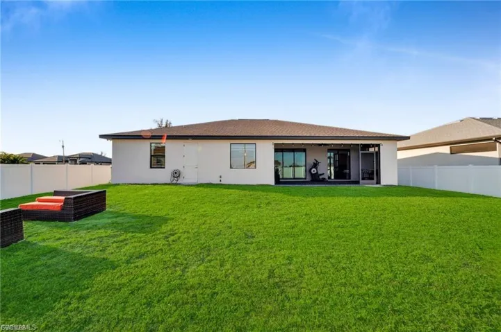 Rear view of house with a fenced backyard, stucco siding, and a patio