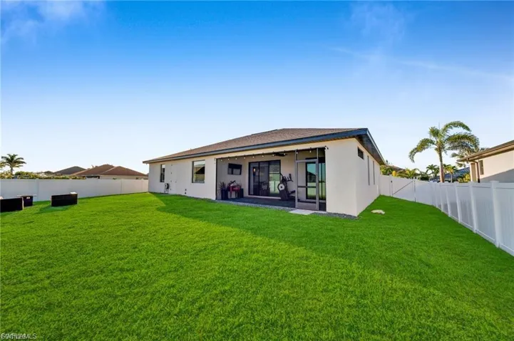 Rear view of house featuring a fenced backyard, a patio area, and stucco siding