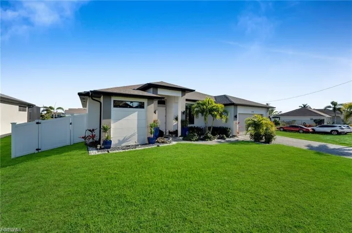 Prairie-style home with a gate, stucco siding, a garage, and driveway