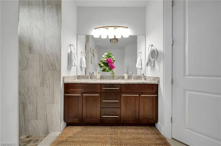 Full bathroom featuring double vanity and a tile shower