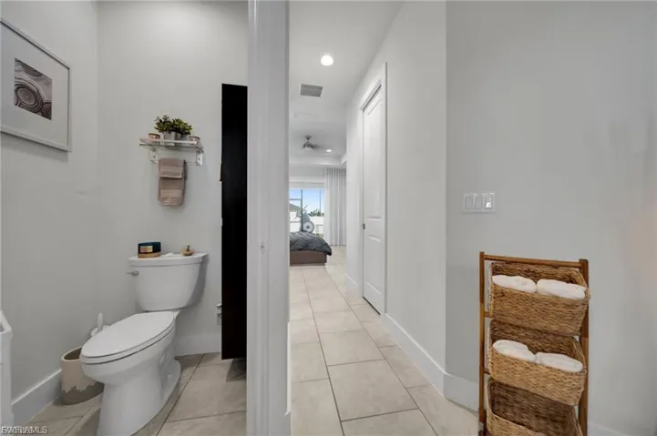 Bathroom with ensuite bathroom, light tile patterned flooring, and recessed lighting