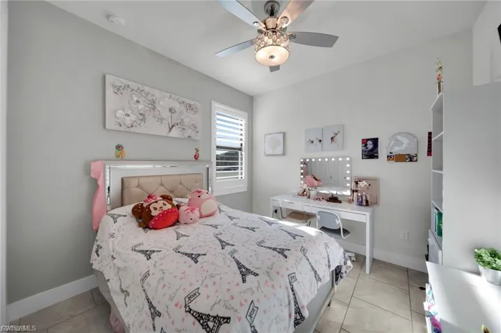 Bedroom with light tile patterned floors and ceiling fan