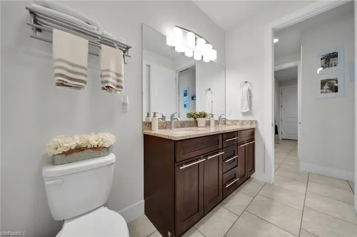 Full bath with double vanity and light tile patterned flooring