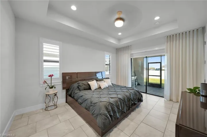 Bedroom featuring light tile patterned flooring, access to outside, multiple windows, and recessed lighting