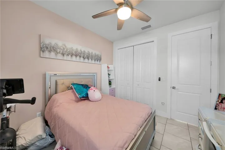 Bedroom featuring ceiling fan, a closet, and light tile patterned flooring