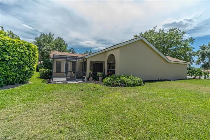 Back of property with a sunroom and a yard