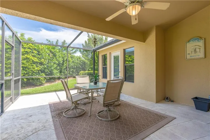 View of patio featuring glass enclosure and ceiling fan