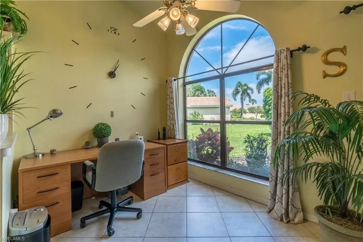Tiled office space featuring a healthy amount of sunlight and ceiling fan