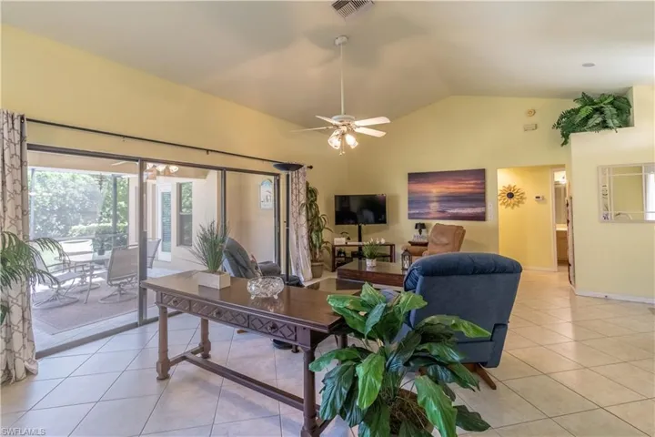Tiled living room with high vaulted ceiling and ceiling fan